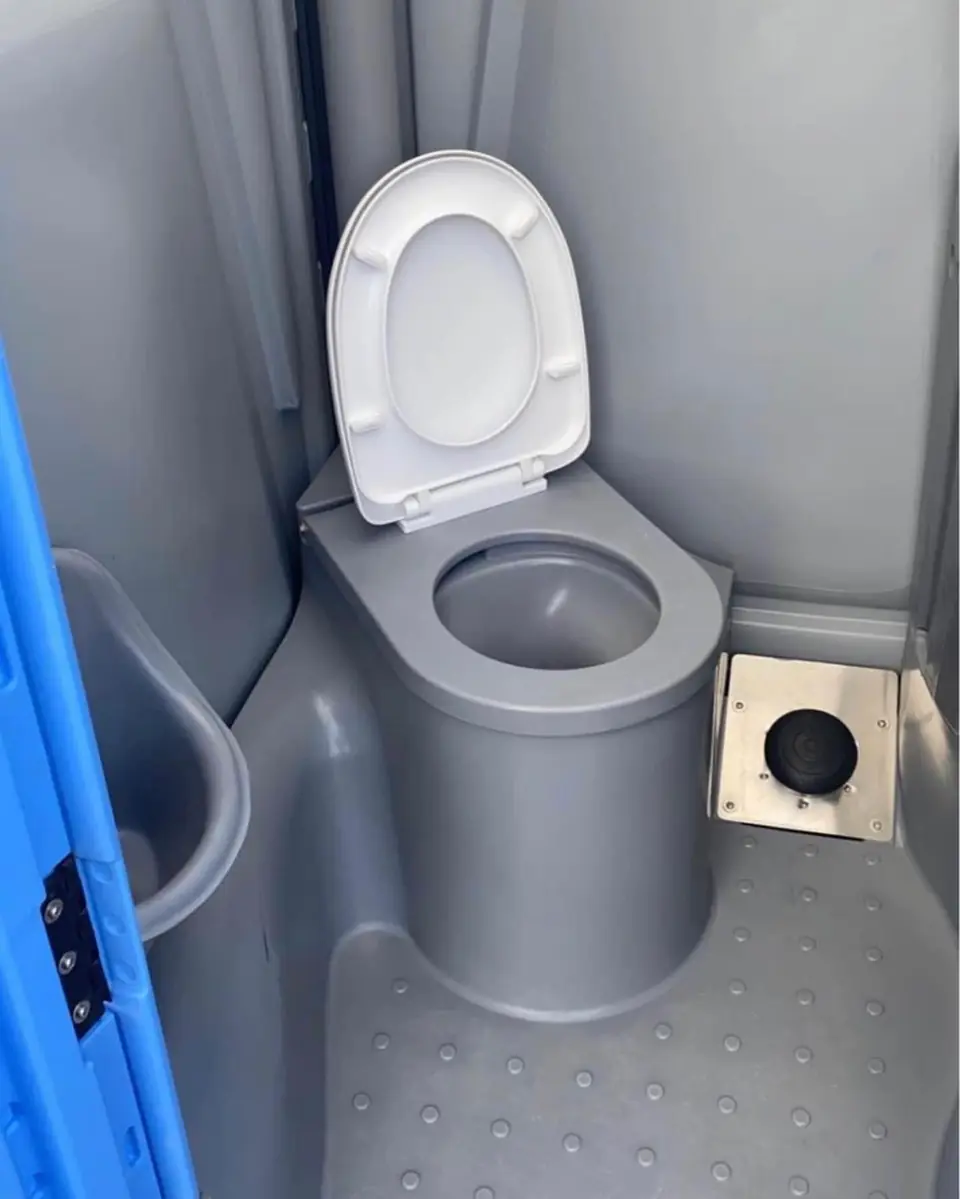 Clean gray porta potty interior with white toilet seat and non-slip floor
